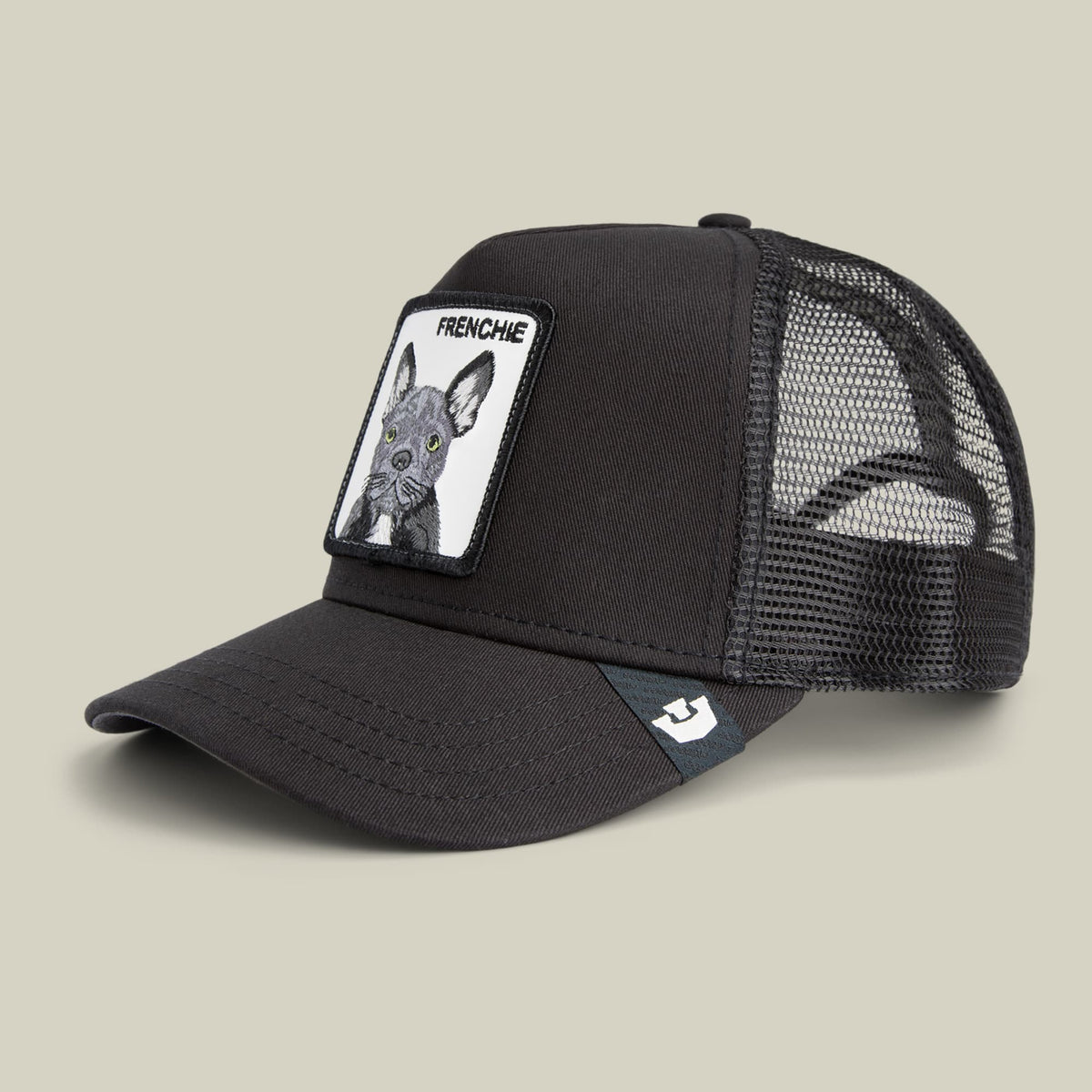 The Goorin Bros. Frenchie Trucker Mini is a black mesh-back snapback cap featuring a white patch with a French Bulldog illustration and text reading "FRENCHIE" on the front, shown against a neutral beige background.