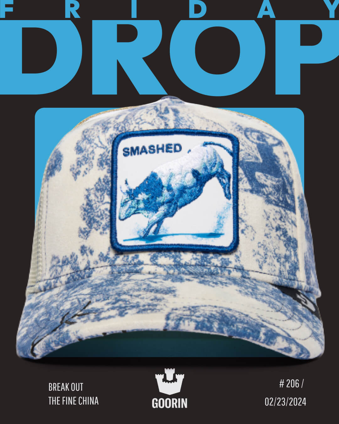 A blue and white patterned baseball cap from Goorin, featuring a patch with a charging rhino and the word SMASHED, showcased in a Friday Drop Goorin ad—perfect for fans of unique trucker hats.