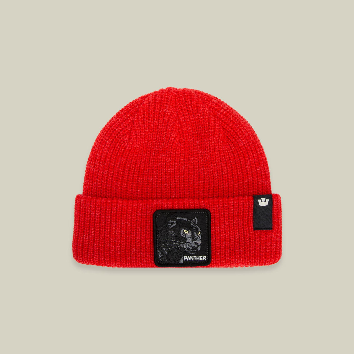 The Panther Beanie Mini by Goorin Bros is a bright red ribbed knit cuffed beanie featuring a black patch with panther embroidery and gold eyes on the front, displayed against a neutral studio background.