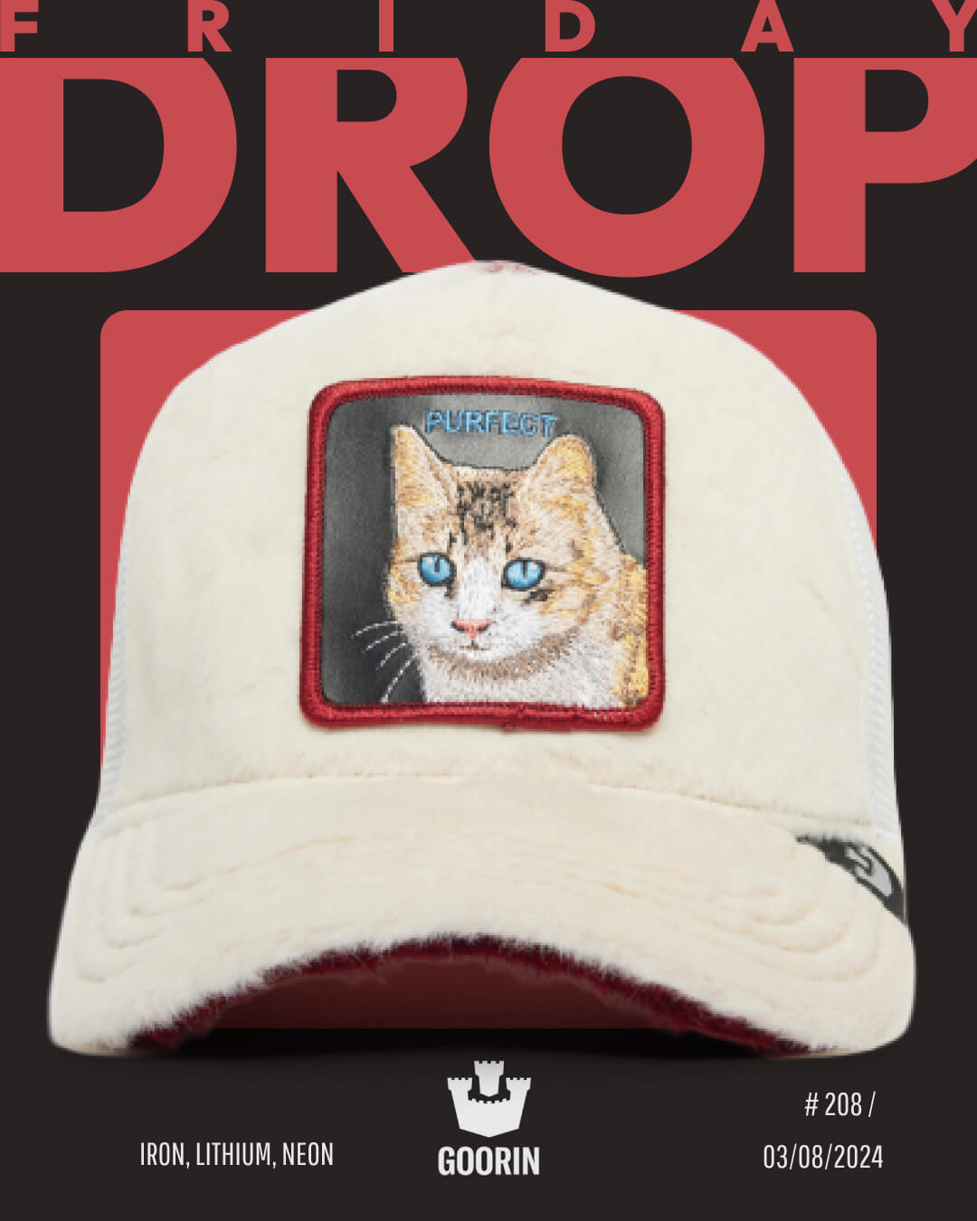 A cream-colored Goorin trucker hat with a bold cat patch and the word PURRFECT on the front. FRIDAY DROP appears above. Release info at the bottom—celebrate bold hat designs with this standout piece.