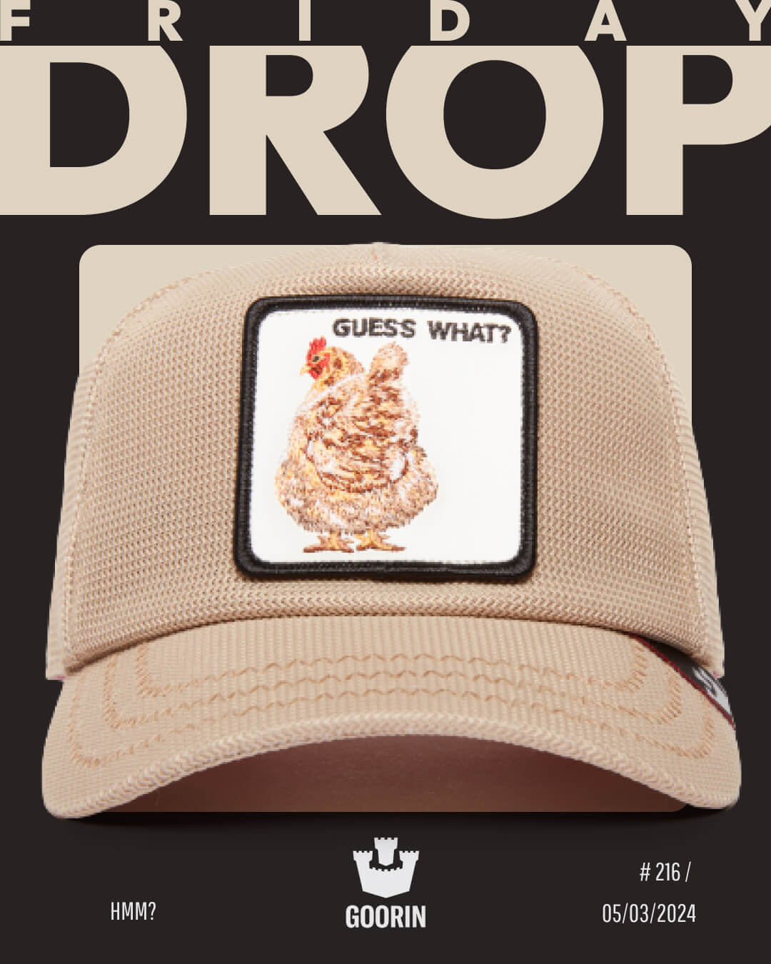 A beige mesh trucker hat by Goorin with a patch featuring a chicken and the text “GUESS WHAT?” is displayed against a black background with “FRIDAY DROP” at the top.