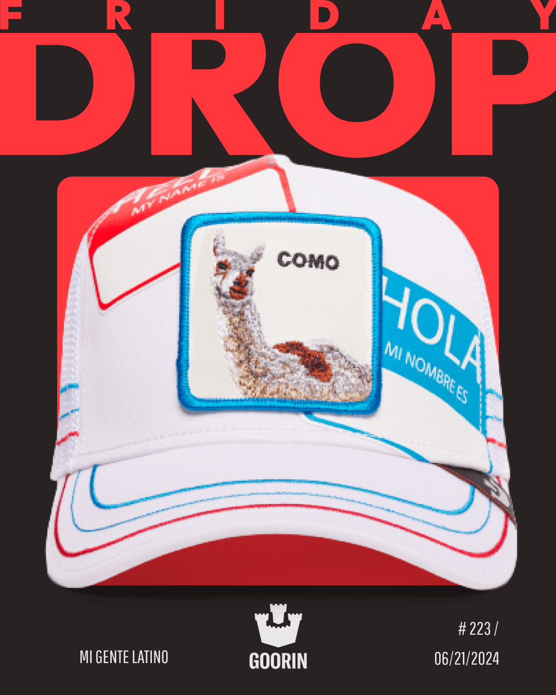 A white Goorin trucker hat featuring a patch with a llama and the word COMO, surrounded by bold hat designs like name tag graphics with HOLA and MY NAME IS text.