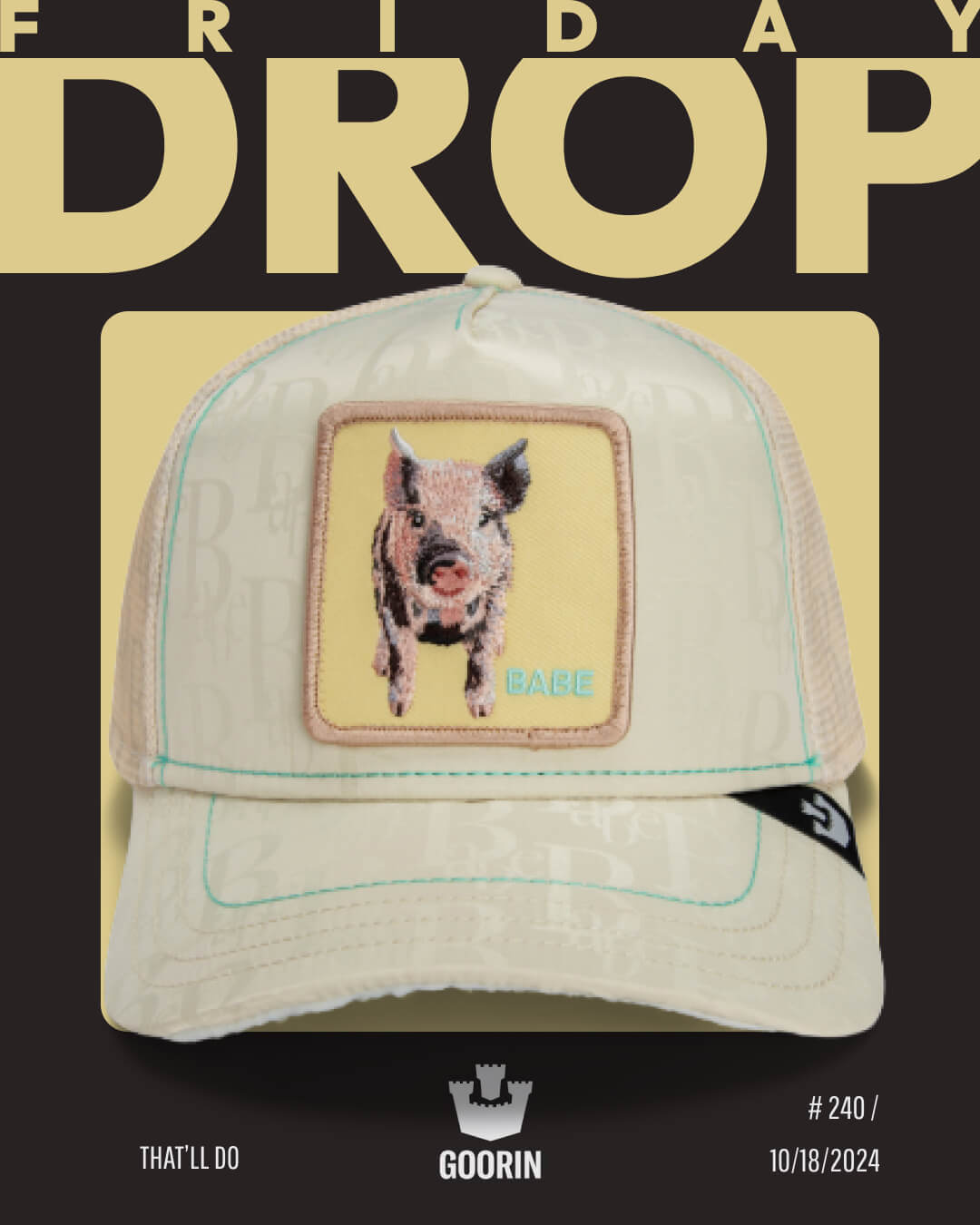 A beige mesh cap by Goorin with a patch showing a pig and the word BABE, displayed on a bold black and yellow promotional background for a Friday drop—perfect for fans of bold hat designs.