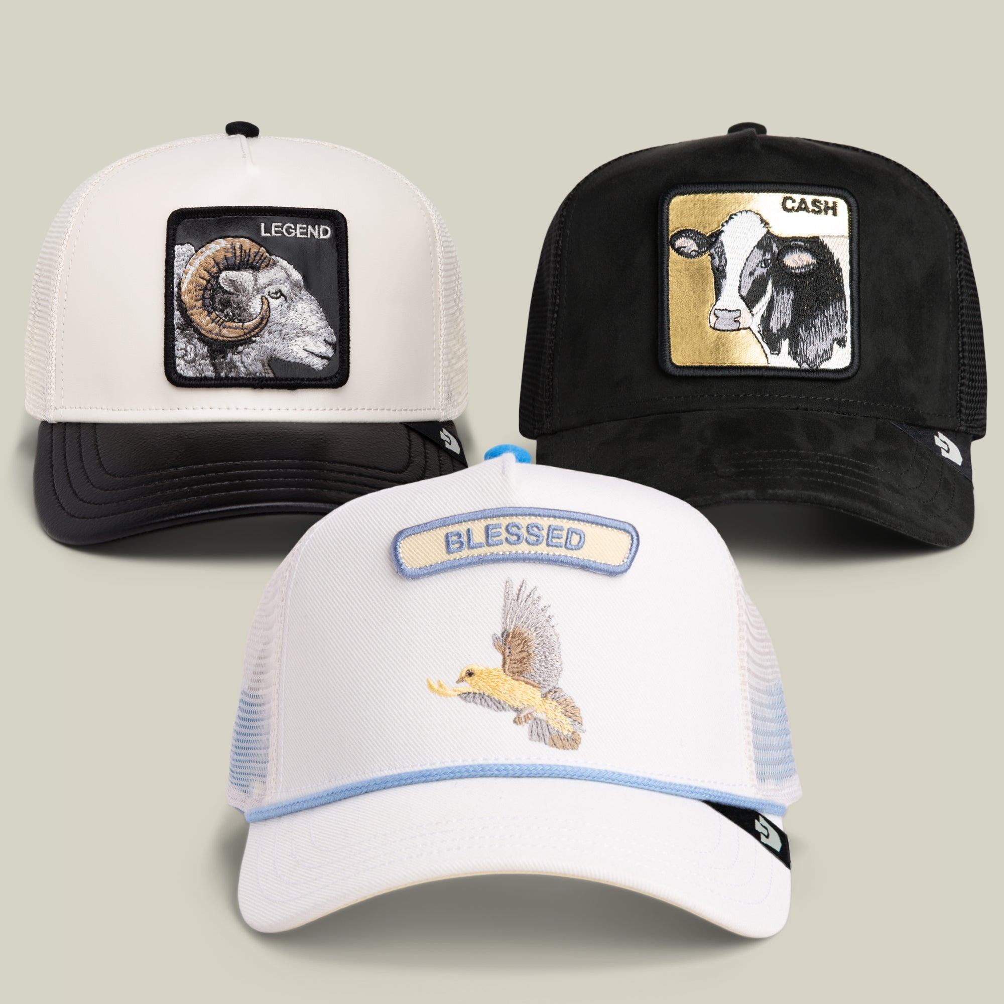 Introducing the 24 Hours of Labor Bundle from Goorin Bros.: three trucker hats featuring unique embroidered patches—a ram with LEGEND, a cow with CASH, and a front hat with an eagle and BLESSED. Each hat comes with a mesh back for comfort, offering the perfect way to add personal flair or a playful twist to your everyday style.
