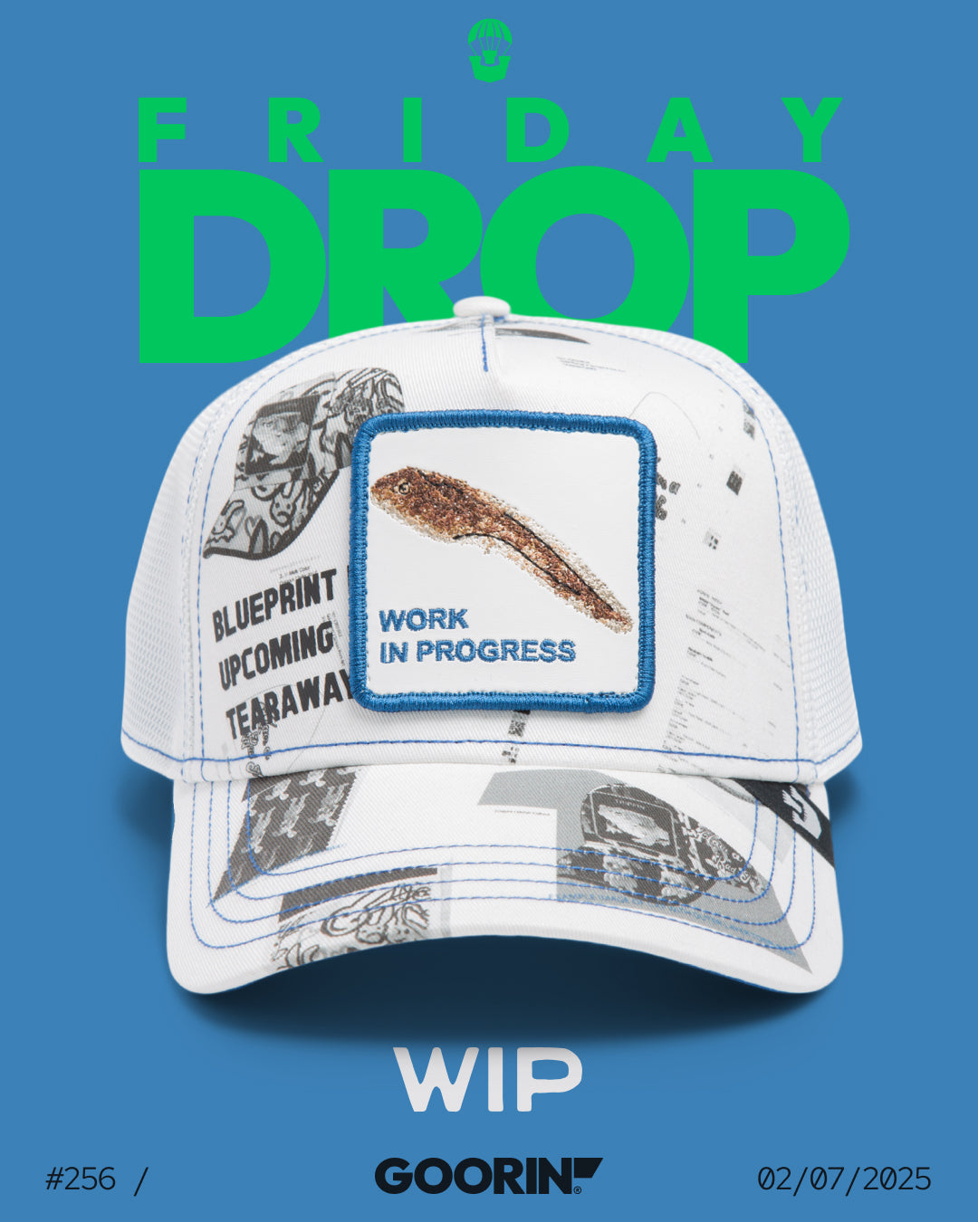 A white Goorin cap featuring blueprint-style graphics and a patch with a brown paintbrush labeled Work in Progress, with FRIDAY DROP text above—crafted for fans of durable hats.
