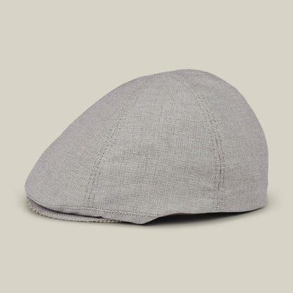 The Goorin Bros. Mile Rock is a gray 6-panel Ivy flat cap with a subtle checkered pattern, hand cut and sewn, shown from the side on a plain beige background.