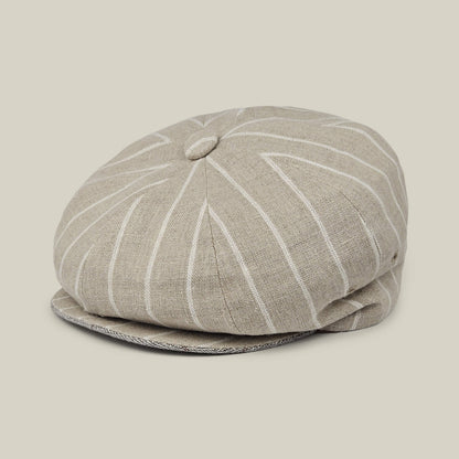 The Rincon Park newsboy cap by Goorin Bros. features a beige linen blend with white pinstripes, a top button, and a classic Gatsby silhouette, displayed on a neutral background.