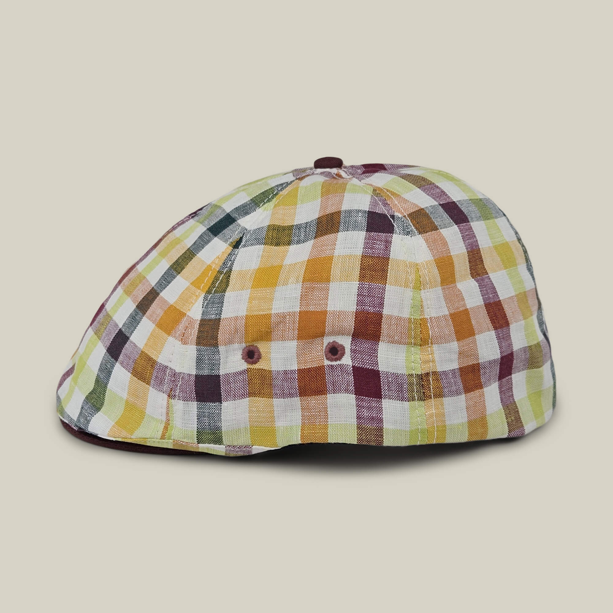 The Goorin Bros. Point Lobos features a yellow, green, orange, and burgundy plaid check pattern in a classic 6 Panel Ivy flat cap style, made from a breathable cotton blend and shown in profile view against a light beige background.