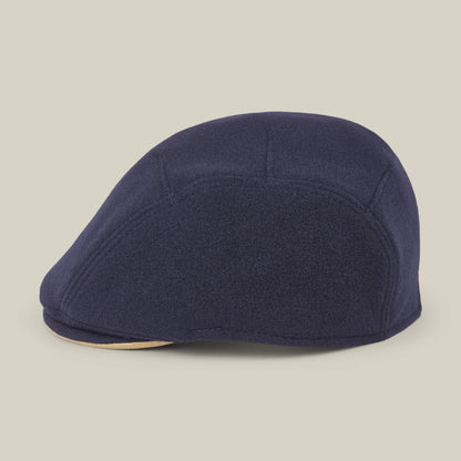 The Goorin Bros. Cornerstone is a navy blue flat cap, handmade in New Jersey with a curved brim and visible stitching, shown in profile against an off-white background.