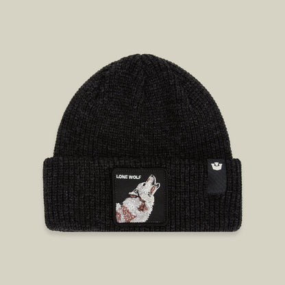The Lone Wolf Beanie by Goorin Bros. is a black knit hat featuring a howling wolf patch with the words “LONE WOLF” on the front, along with a small logo tag on the cuff. Displayed against a beige background, this winter hat combines warmth and style.