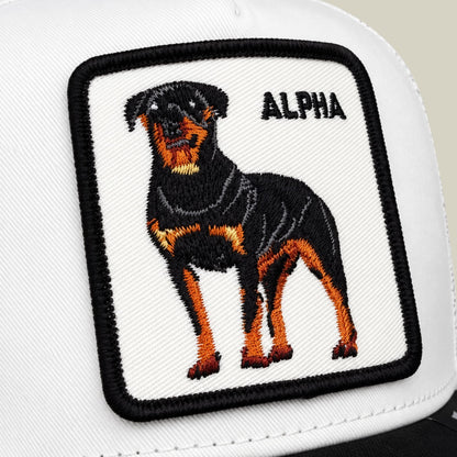 The Suede Alpha by Goorin Bros is a white trucker hat featuring an embroidered black and orange rottweiler patch with the word "ALPHA" on the front panel.