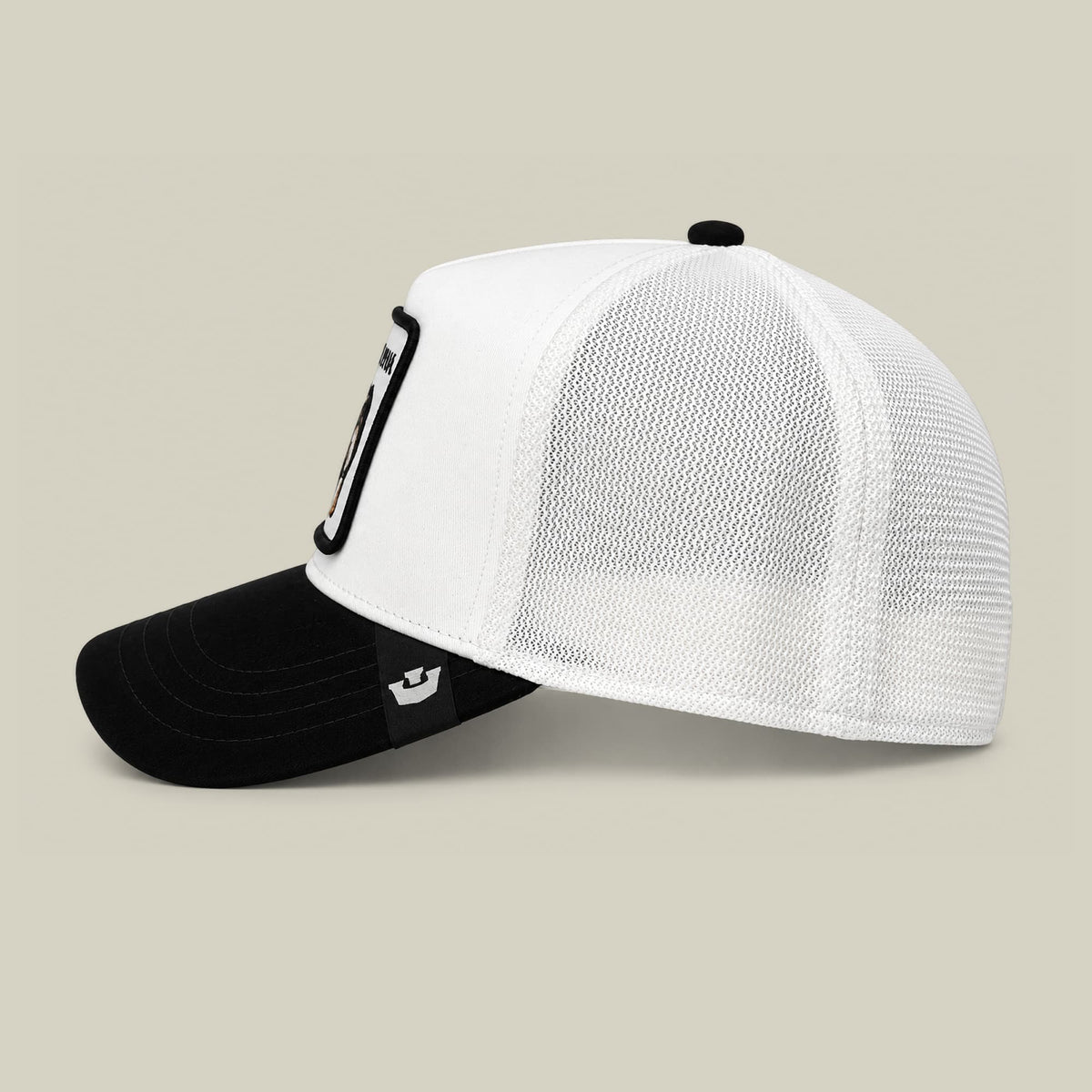 The Goorin Bros. Suede Alpha trucker hat features a white mesh back panel, black suede front bill, and a black carabiner clip accent on the side, displayed against a neutral studio background.