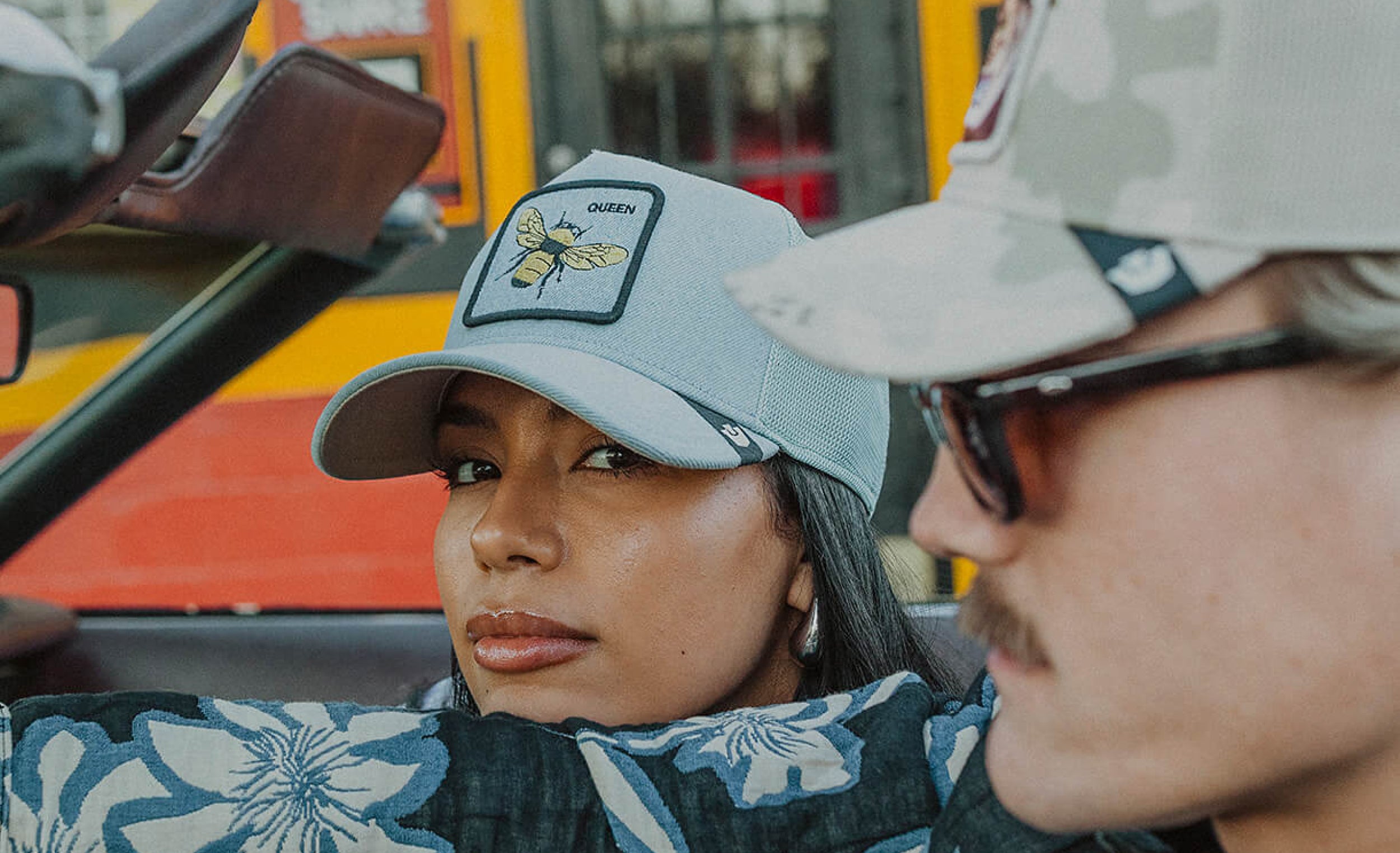 Two people wearing baseball caps with a blurred background