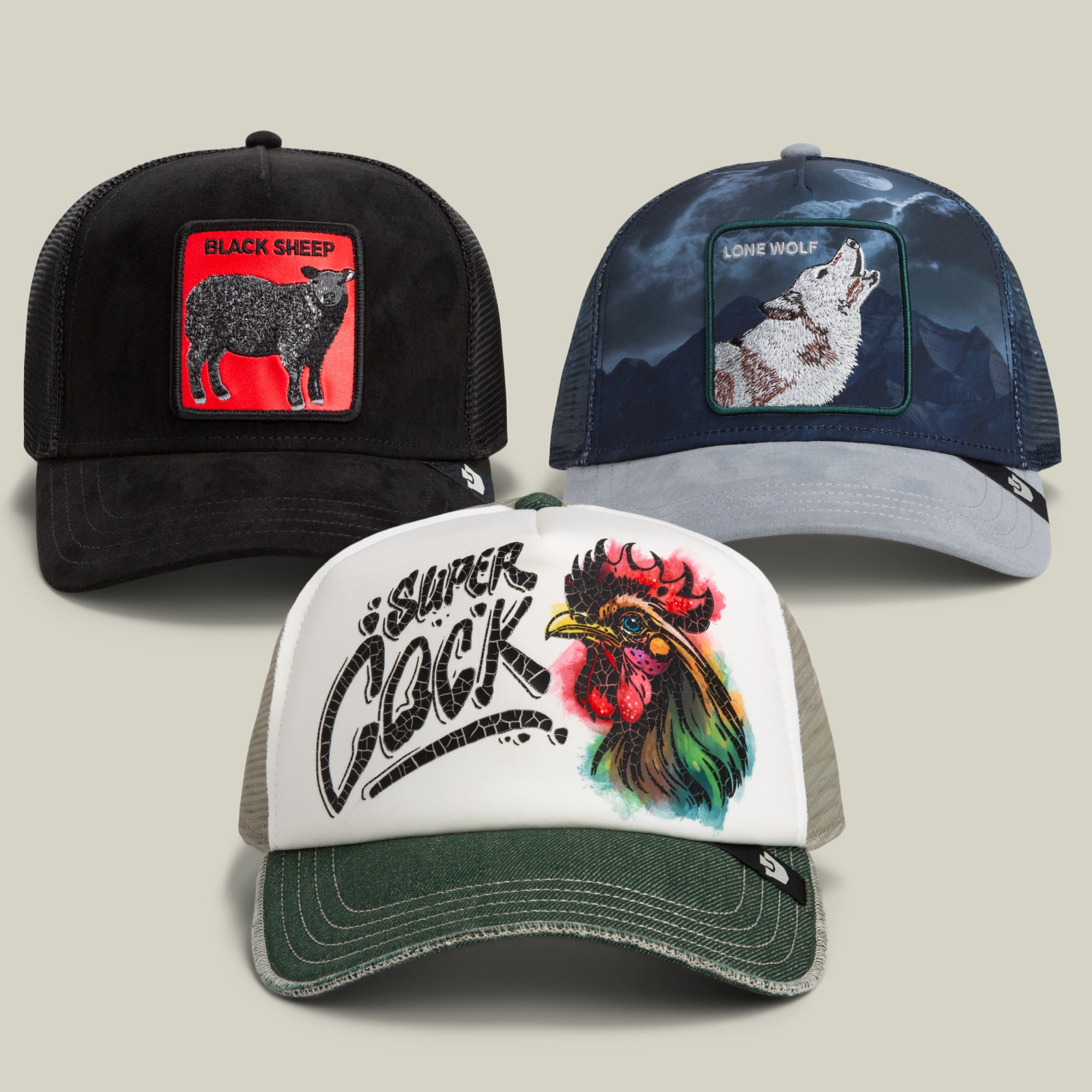 Three trucker hats from the Goorin Bros. Maximum Evolution Bundle are displayed: one features a black sheep patch, another shows a howling wolf radiating night-prowling confidence, and the third displays a multicolored rooster with bold Super Cock text on the front.