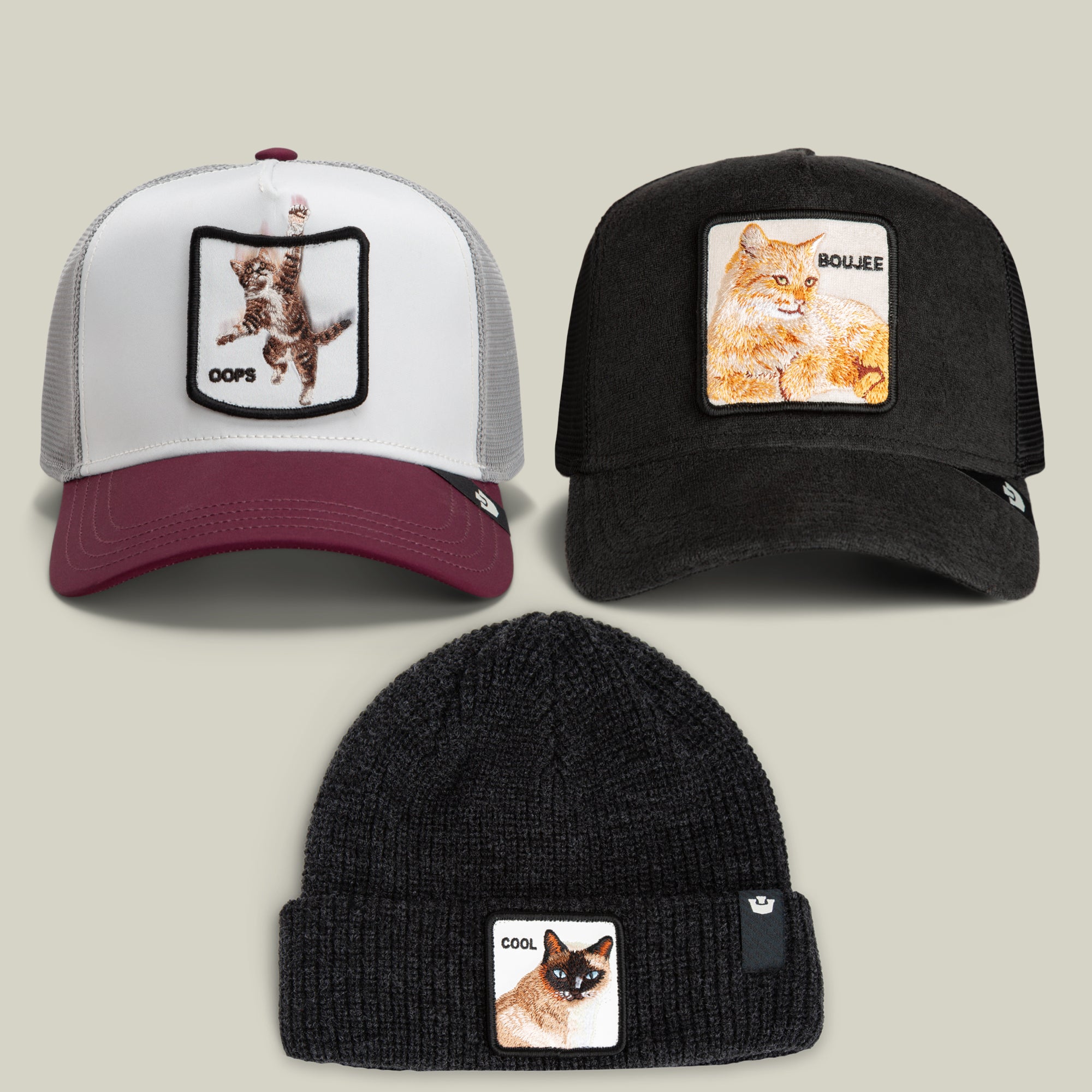 The Goorin Bros. Nine Lives Bundle features three hats: two trucker caps with embroidered cat patches labeled OOPS and BOUJEE, showcasing the playful spirit of mischievous cats, along with a knit beanie adorned with an embroidered cat patch labeled COOL.