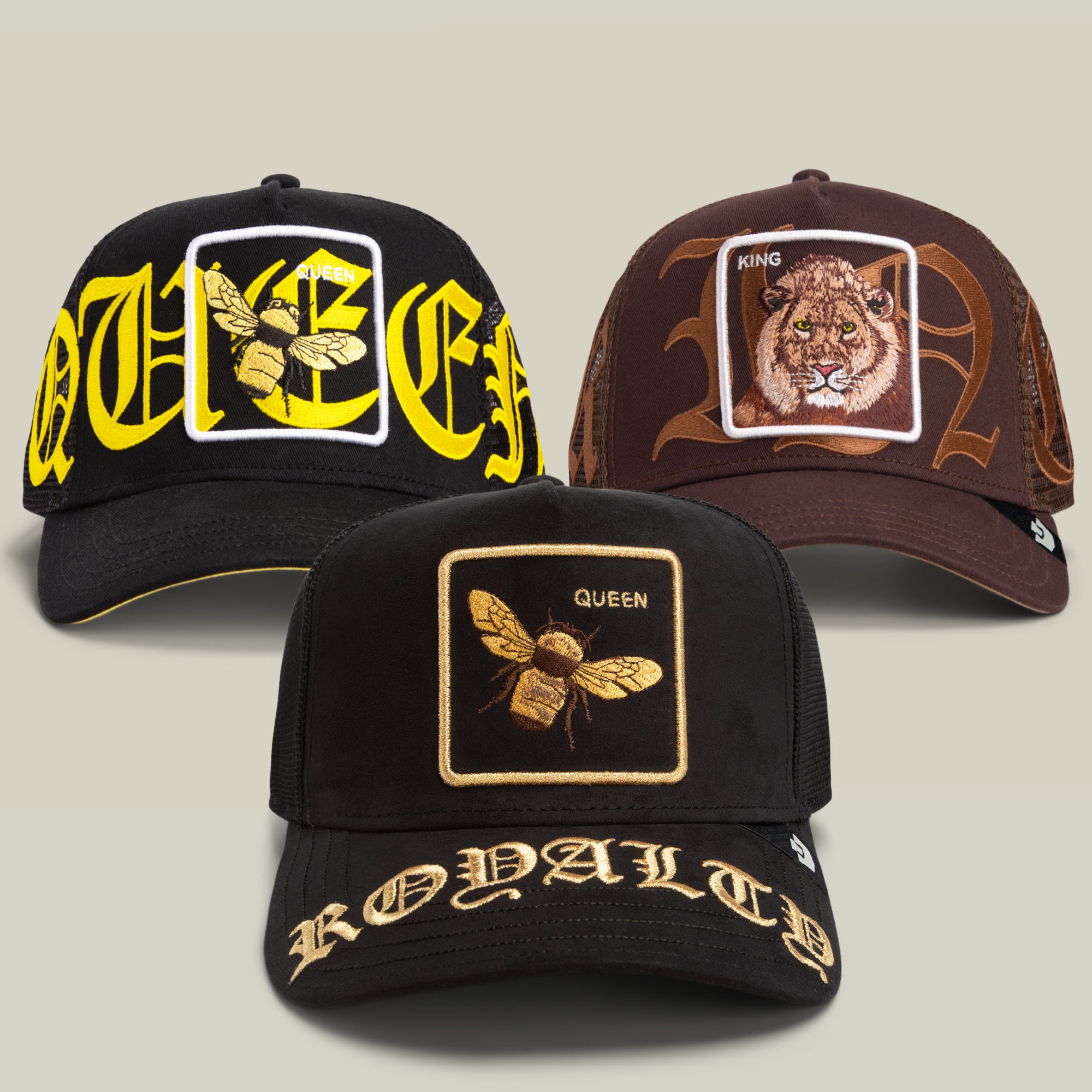 The Olde School Bundle by Goorin Bros. includes three baseball hats adorned with bold embroidered patches: two display bees alongside the word “QUEEN,” while the third features a lion and the word “KING.” Each hat is detailed with stylized Gothic lettering stitched across the brim and front, capturing a regal, animal-inspired aesthetic.