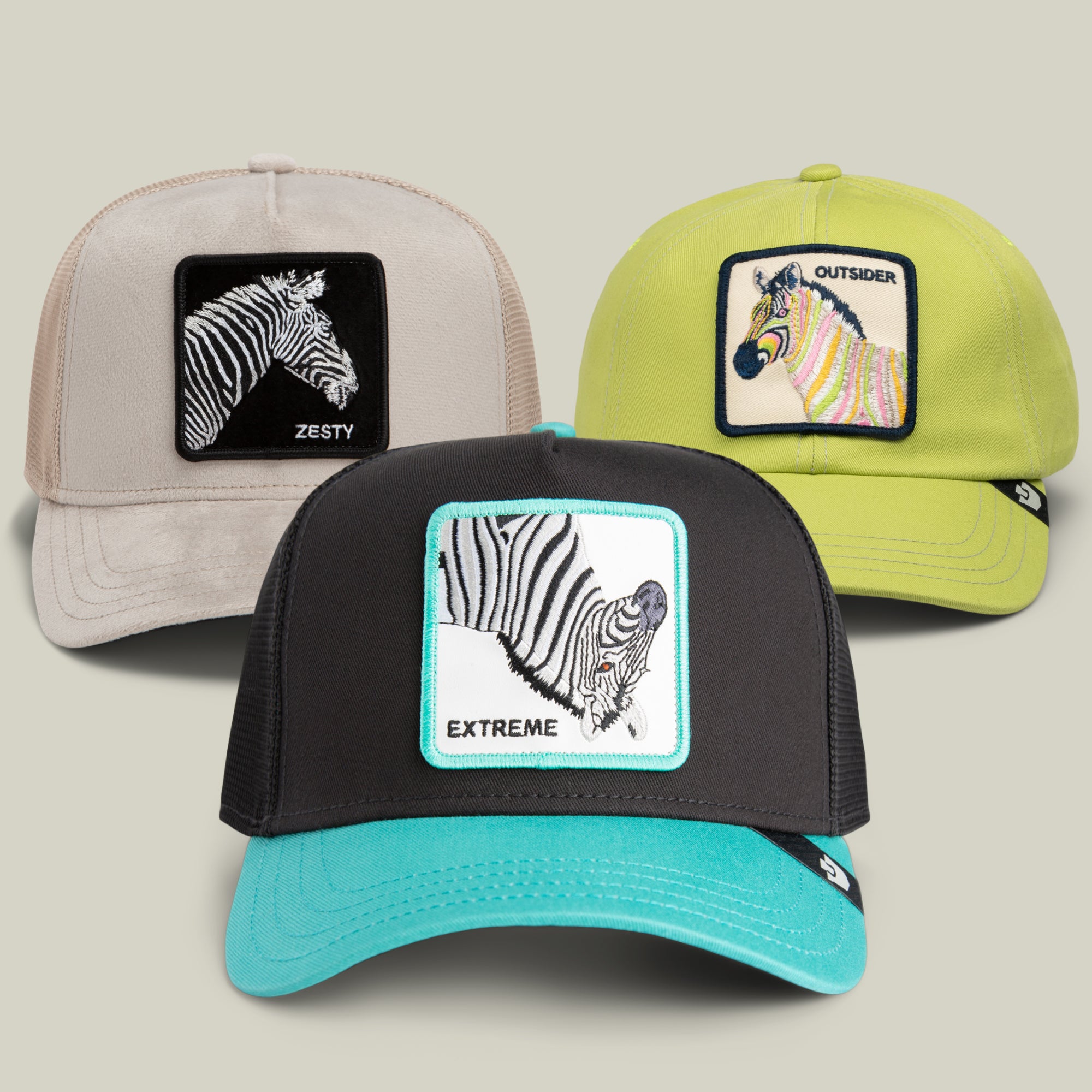 The Stripes and Stripes Bundle by Goorin Bros. includes three trucker hats with bold animal print zebra patch designs: a beige hat featuring the Zesty patch, a lime green hat with the Outsider patch, and a black and teal hat embroidered with EXTREME text.