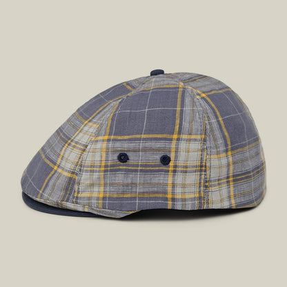 The Goorin Bros. Point Lobos is a gray, blue, and yellow plaid 6-panel Ivy flat cap featuring button accents and two small side ventilation holes. Crafted from a breathable cotton blend, it is displayed against a neutral background.