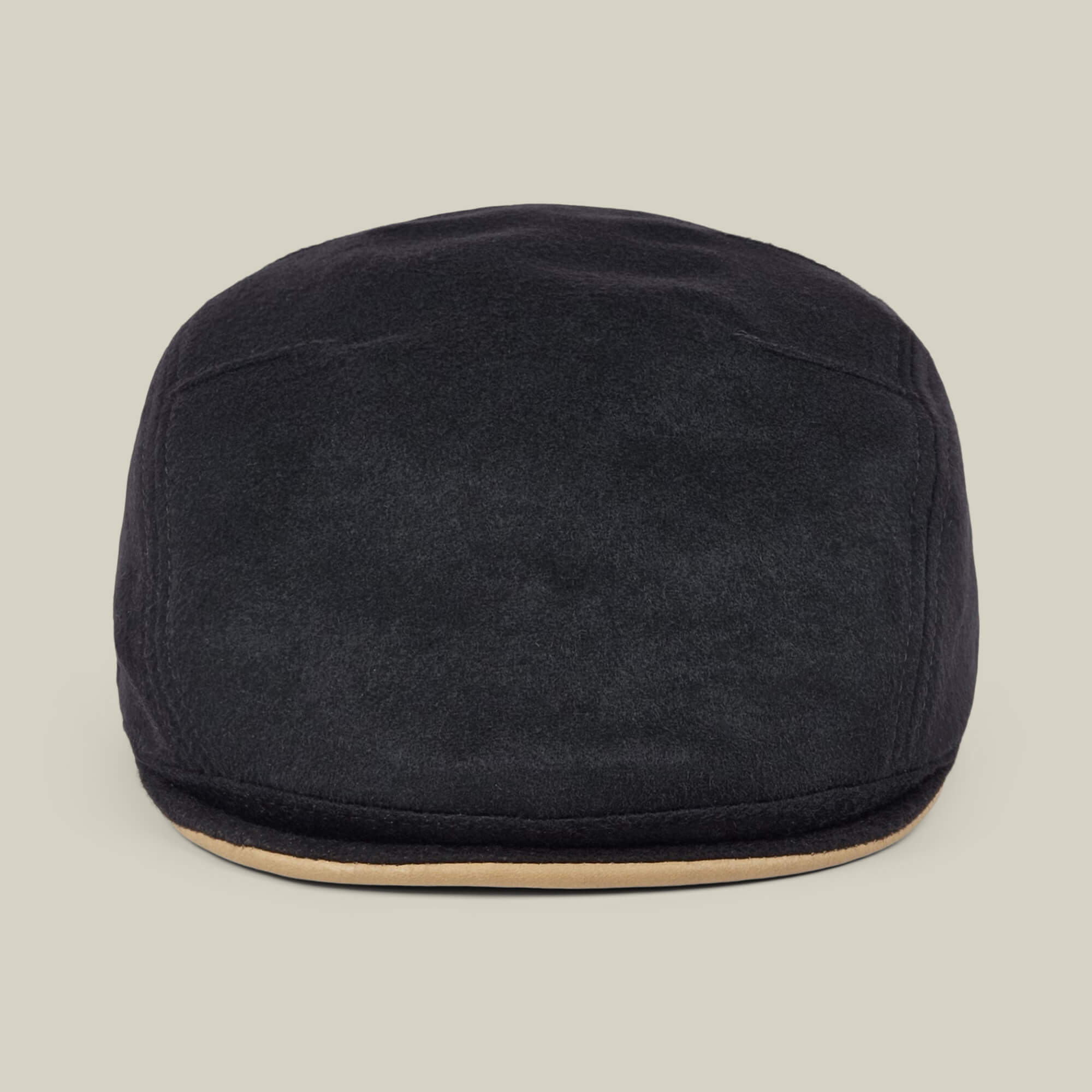 The Goorin Bros. Cornerstone is a black wool flat cap featuring a slightly curved brim and a beige accent along the edge, handmade in New Jersey and displayed against a plain light background.