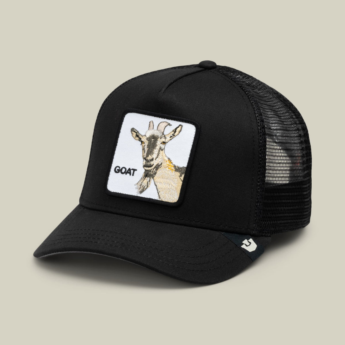 The Goorin Bros. Goat Beard black trucker hat features a mesh back, curved brim, and white patch with a beige goat illustration and "GOAT" text on the front.